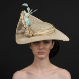 Latte coloured sinamay brimmed hat, with a spray of diamond cut feathers in light orange, coffee, cream. Hand made by Rivka Jacobs Millinery