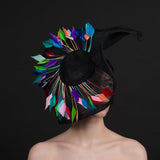Big black fascinator with a spray of multi coloured feathers