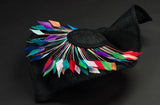 Big black fascinator with a spray of multi coloured feathers
