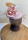 Pink rose hat/fascinator, with white veil, pink strae rose to match base and light green feathers. rivka jacobs millinery. hats uk devon