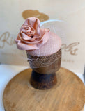 Pink rose hat/fascinator, with white veil, pink strae rose to match base and light green feathers. rivka jacobs millinery. hats uk devon