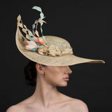 Latte coloured sinamay brimmed hat, with a spray of diamond cut feathers in light orange, coffee, cream. Hand made by Rivka Jacobs Millinery