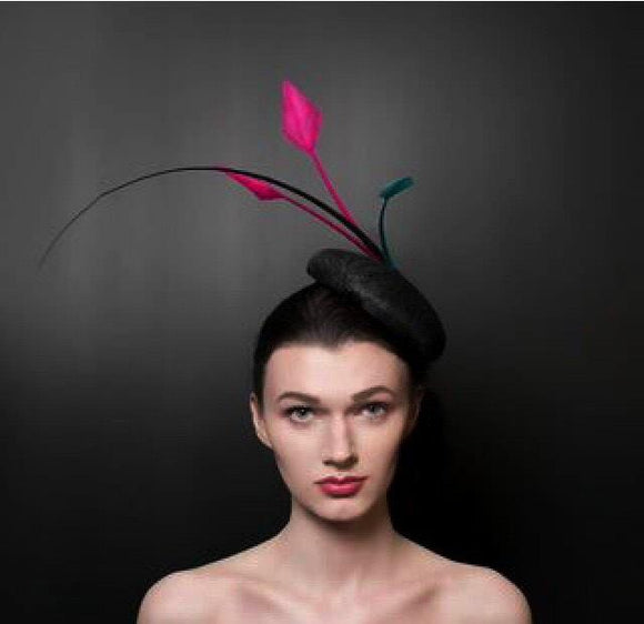 Black button beret with black quill, and striking pink arrow feathers