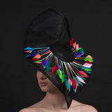 Big black fascinator with a spray of multi coloured feathers 