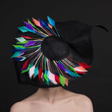 Big black fascinator with a spray of multi coloured feathers 