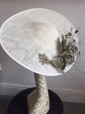 Large white saucer hat with spray of black and white feathers and dimonte motif
