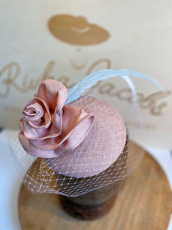Pink rose hat/fascinator, with white veil, pink strae rose to match base and light green feathers. rivka jacobs millinery. hats uk devon