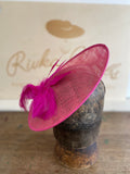 Shocking pink saucer hat with a big spray of pink feathers